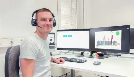 WEBER Mitarbeiter im Buero mit Kopfhoerern